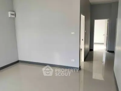 Spacious empty room with glossy tiled floors and neutral walls, ready for customization.