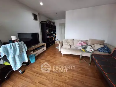 Cozy living room with wooden flooring, modern furniture, and entertainment setup.