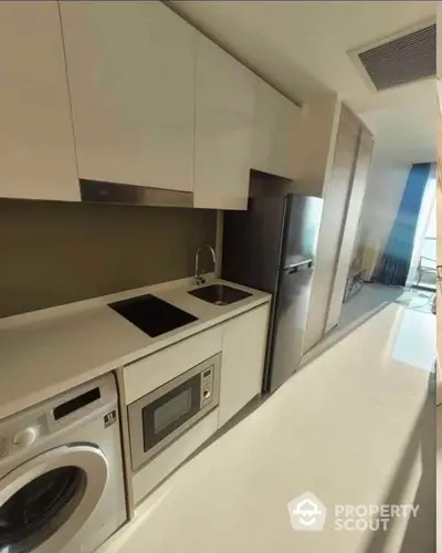 Modern kitchen with sleek appliances and stylish cabinetry in a bright apartment