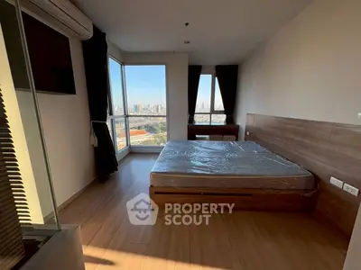Modern bedroom with city view and large windows in high-rise apartment