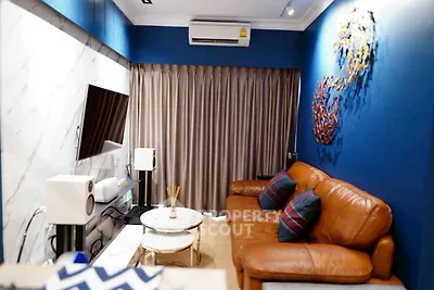 Stylish living room with leather sofa, modern decor, and wall-mounted TV in a cozy apartment.