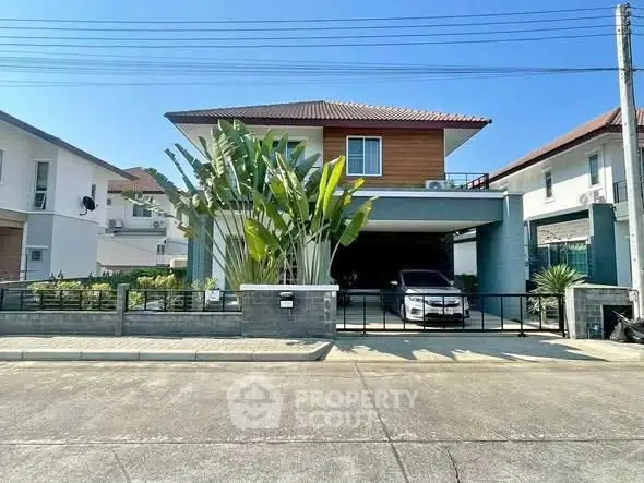 Charming two-story house with a modern design, spacious driveway, and lush greenery in a serene neighborhood.