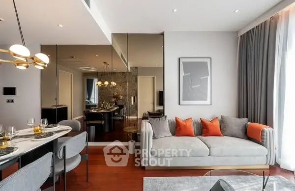 Modern living room with elegant decor and dining area, featuring stylish lighting and cozy seating.