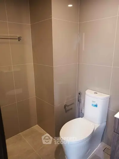 Modern bathroom with sleek tile design and contemporary toilet fixture.