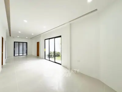 Spacious modern living room with large windows and garden view, perfect for natural light lovers.