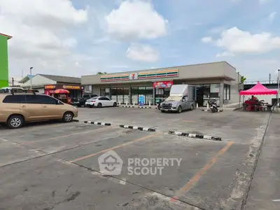 Spacious parking lot in front of a convenience store with clear skies.