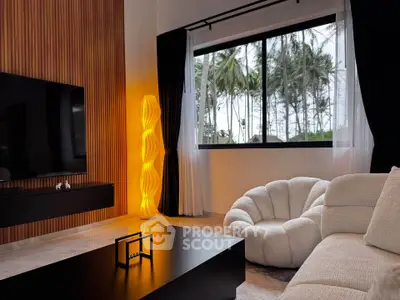 Modern living room with stylish furniture and large window view of palm trees.