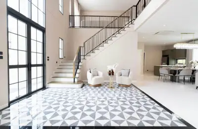 Luxurious modern living room with high ceilings and elegant staircase, perfect for sophisticated living.
