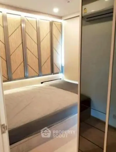 Modern bedroom with stylish wall paneling and mirrored closet doors