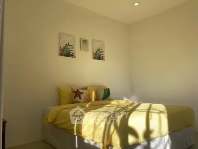 Bright and cozy bedroom with yellow bedding and decorative wall art, perfect for relaxation.