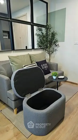 Modern living room with stylish sofa and storage ottoman, perfect for cozy relaxation.