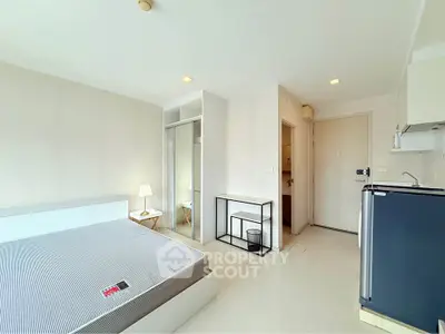 Modern studio apartment with sleek design and compact kitchen area.
