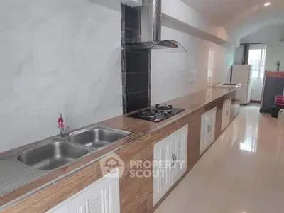 Spacious modern kitchen with sleek countertops and built-in gas stove in a bright apartment.