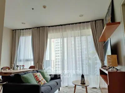 Modern living room with large windows and stylish decor in a high-rise apartment.