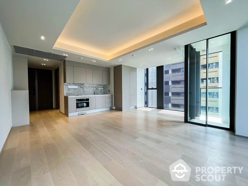 Spacious modern living room with open kitchen and large windows in luxury apartment