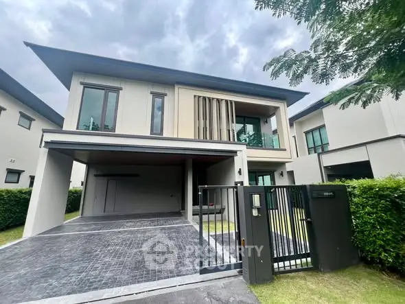 Modern two-story house with sleek design and spacious driveway in a serene neighborhood.