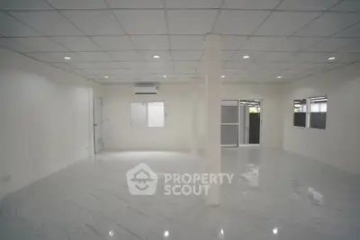 Spacious open-plan interior with modern tiled flooring and ample natural light.