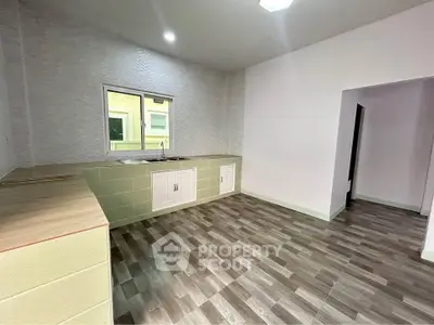 Spacious kitchen with modern flooring and ample counter space, perfect for culinary enthusiasts.