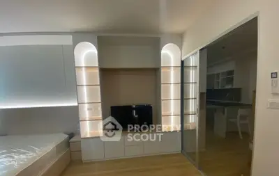 Modern studio apartment with sleek built-in shelving and cozy lighting