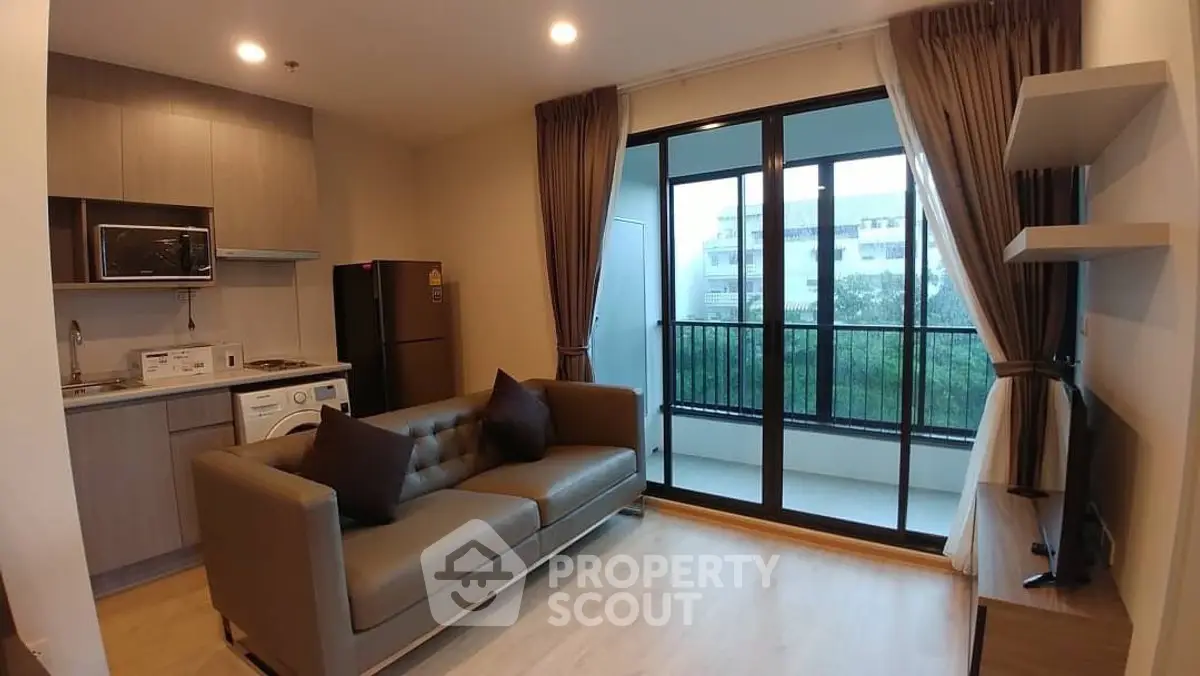 Modern living room with open kitchen and balcony view in urban apartment