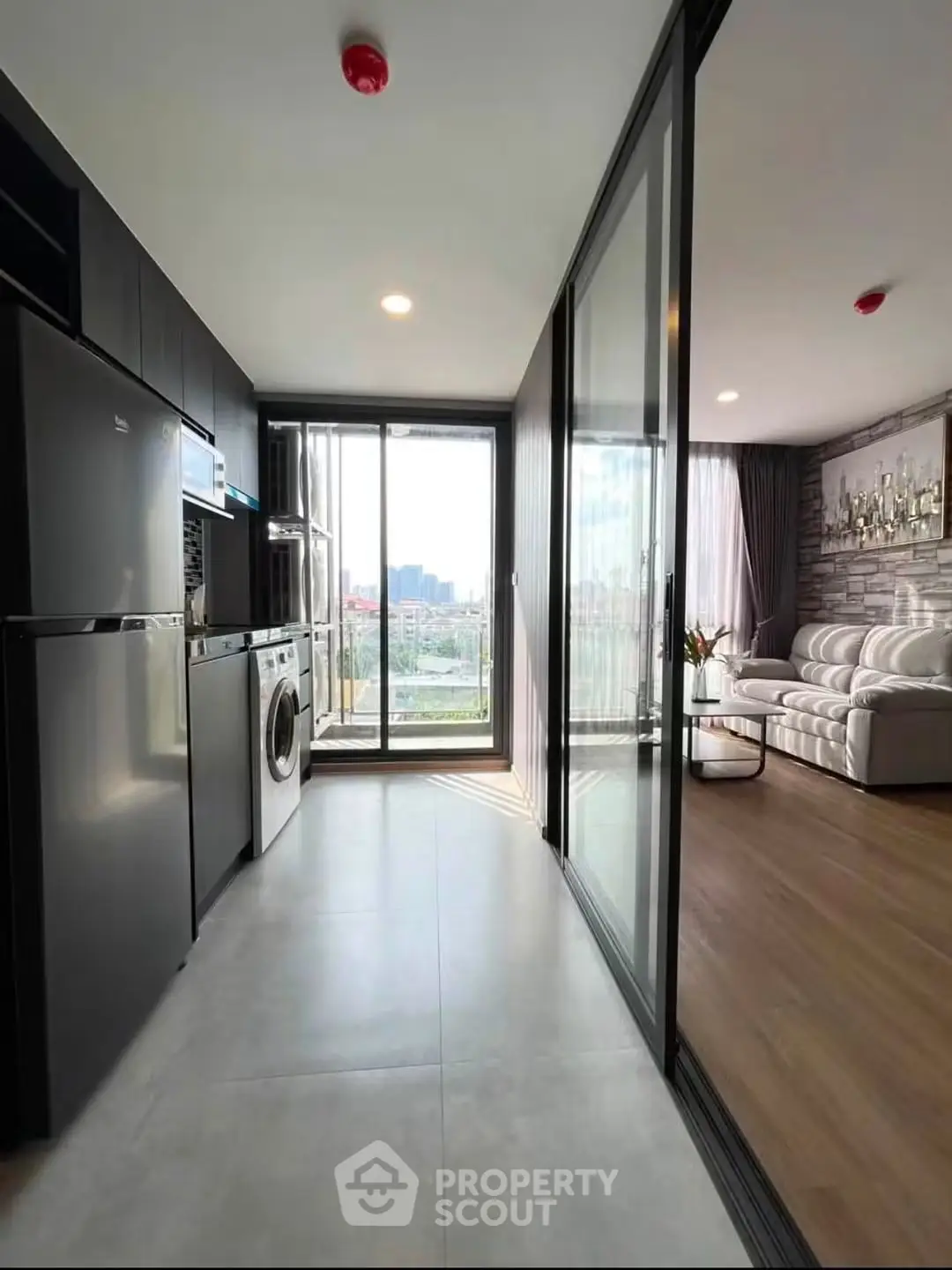 Modern apartment with open kitchen and spacious living room featuring large windows and city view.