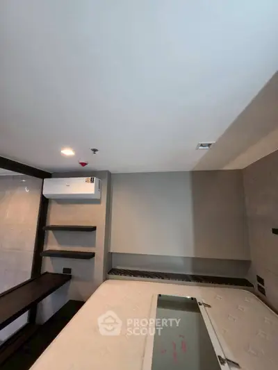Modern bedroom with sleek design and built-in air conditioning unit, featuring minimalist decor and neutral tones.