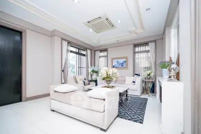 Luxurious living room with elegant decor and natural light, featuring plush seating and stylish accents.