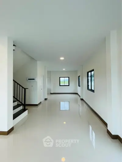 Spacious modern living room with glossy floors and ample natural light.