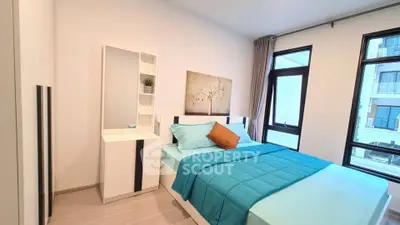 Modern bedroom with stylish decor and large windows in a contemporary apartment.