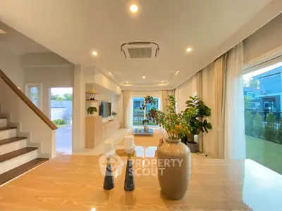 Spacious modern living room with elegant decor and large windows overlooking a lush garden.