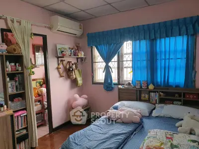 Charming bedroom with cozy decor and ample natural light, featuring a comfortable bed and stylish storage solutions.