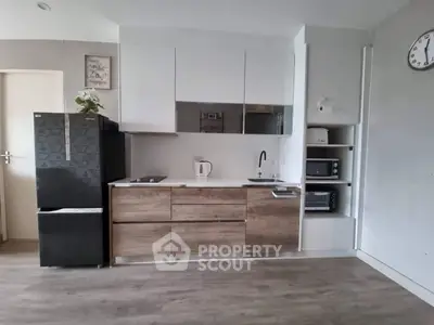 Modern kitchen with sleek cabinetry, compact appliances, and stylish decor in a contemporary apartment.