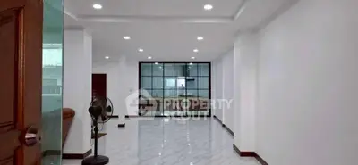 Spacious modern living room with sleek marble flooring and glass partition.