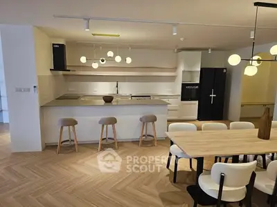 Modern kitchen with open layout, sleek appliances, and stylish dining area in contemporary home.