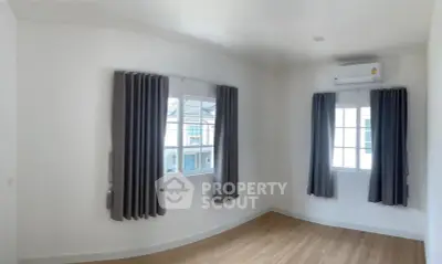 Bright and airy bedroom with large windows and modern air conditioning unit.