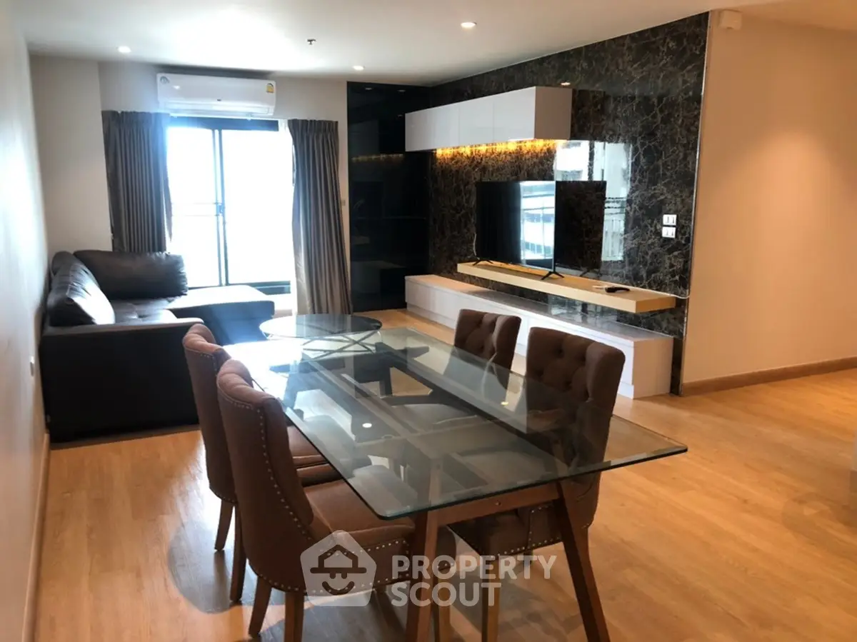Modern living room with glass dining table and stylish decor in a contemporary apartment.