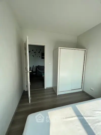 Bright bedroom with minimalist decor and wooden flooring