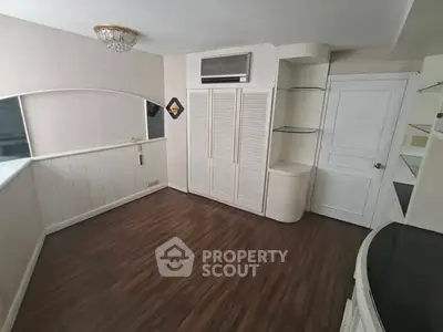 Spacious room with elegant wooden flooring and built-in storage