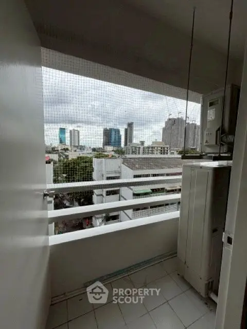 Urban balcony with city view and utility area, perfect for compact living.