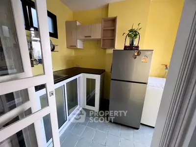 Charming kitchen with modern fridge and ample storage in a cozy layout.