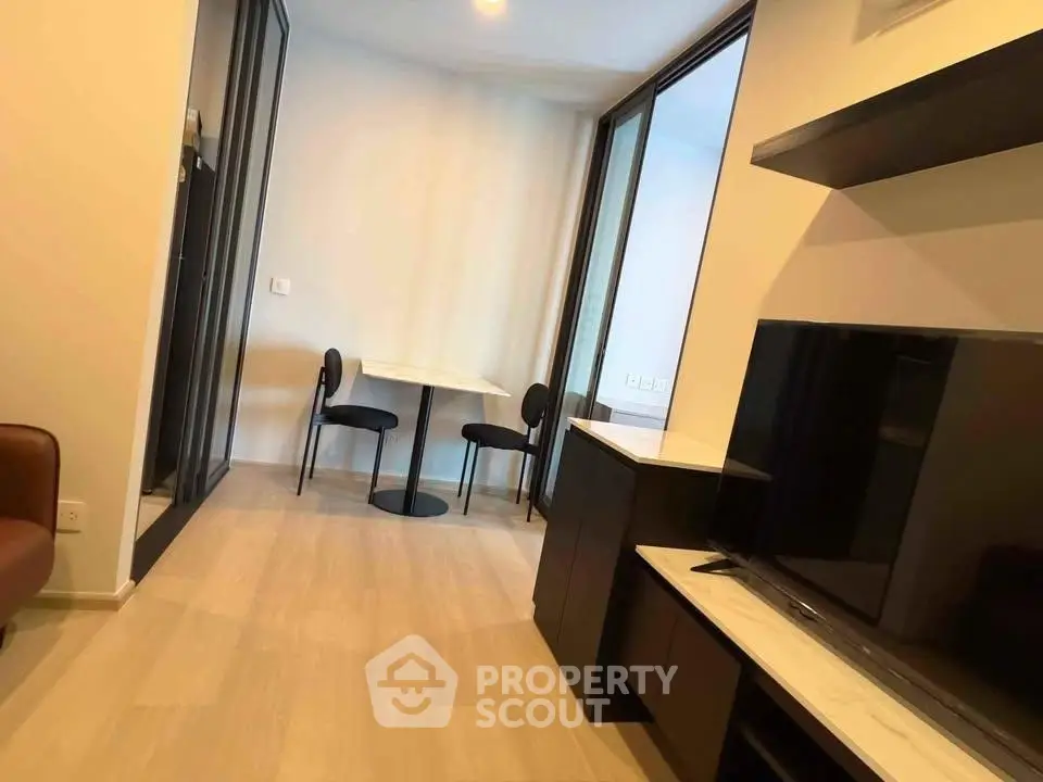 Modern living room with sleek furniture and dining area in a stylish apartment.