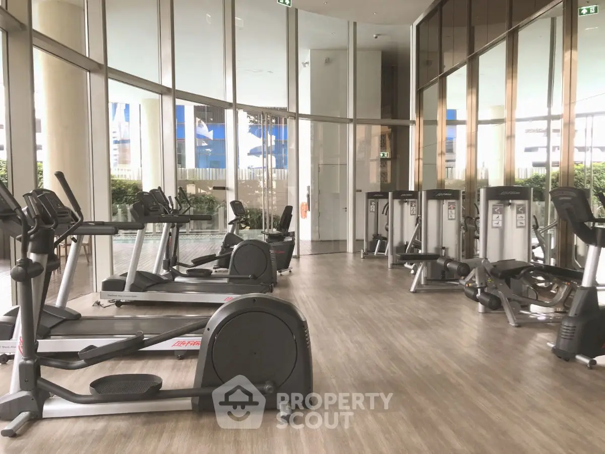 Spacious modern gym with state-of-the-art equipment and floor-to-ceiling windows.