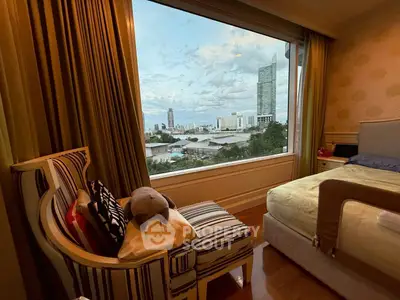 Luxurious bedroom with panoramic city view from large window, elegant furnishings, and cozy ambiance.