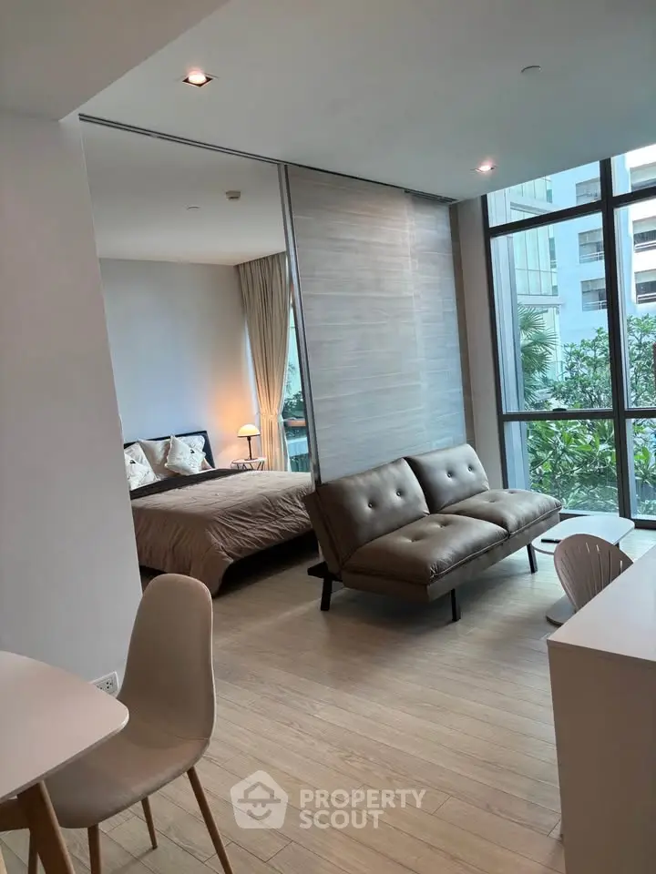 Modern open-plan living room with natural light and stylish furniture in a contemporary apartment.