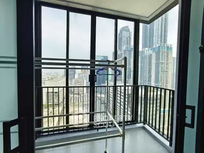 Modern balcony with stunning city view and drying rack in high-rise apartment