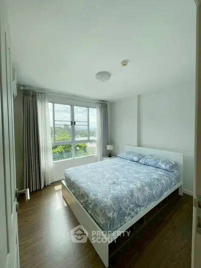 Bright and airy bedroom with large window and scenic view, perfect for relaxation.