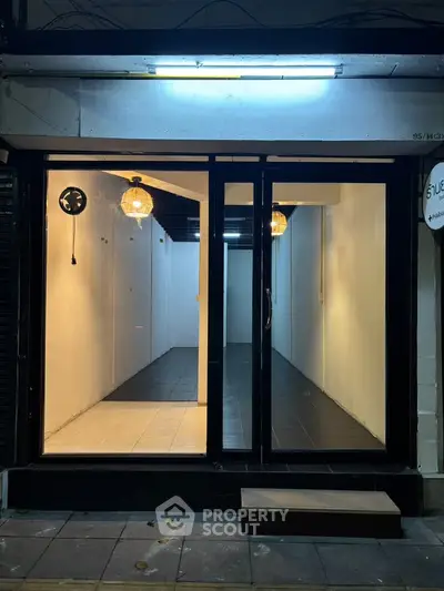 Chic urban storefront with modern lighting and sleek black-tiled flooring, perfect for a trendy business setup.