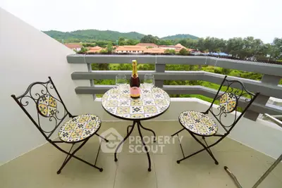 Charming balcony with scenic view, featuring elegant mosaic table and chairs, perfect for relaxation.