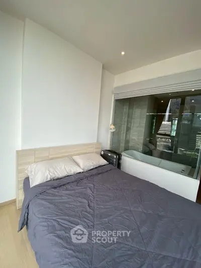 Modern bedroom with cozy bedding and adjacent bathroom view