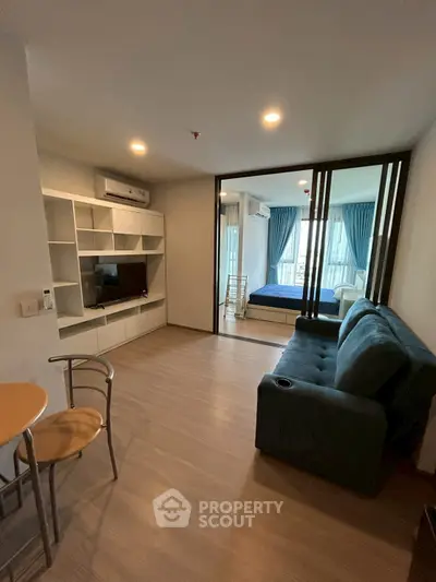 Modern living room with open layout and cozy furniture, featuring a view into a stylish bedroom.